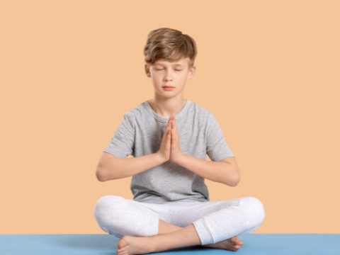 kid sitting in a yoga position