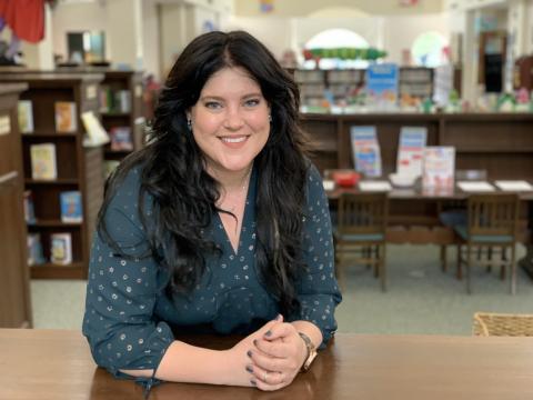 Ruth M. Neely leans on a bookshelf in the Children's Department