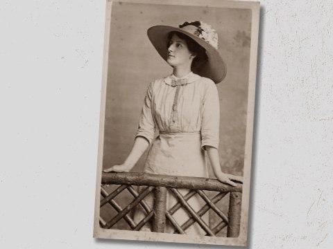 Vintage photo of woman in large hat leaning on railing