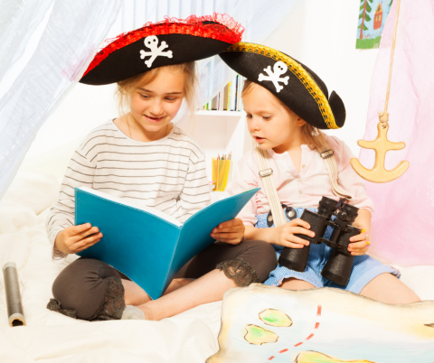 Kids wearing pirates hats and reading a book