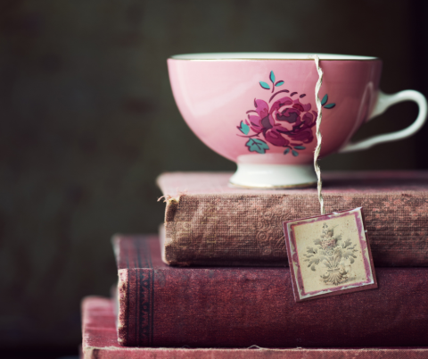 Pink floral teacup on stack of pink books