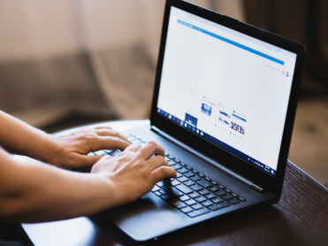 Close up view of a laptop with person's hands typing on keys